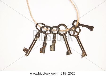 A Lot Vintage Keys On A Rope On White Background