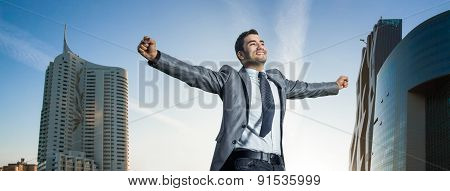 Successful Businessman With His Arms Wide Open. Joyous Man  With Success Perspective, Modern Buildin