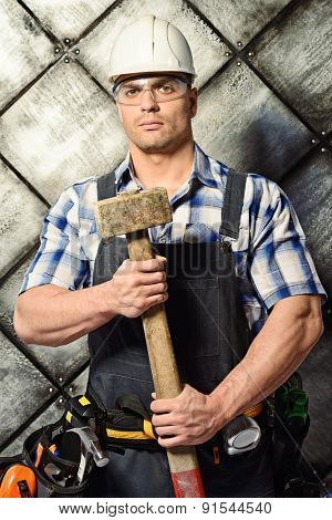 Handsome costruction worker wearing uniform and tools over grunge industrial background. Job, occupation. 