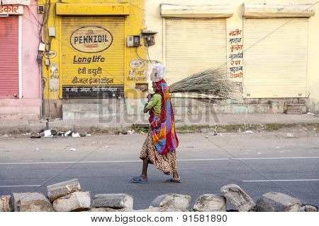 Woman Of Fourt Class In Brightly Colored Clothing Cleans The Street