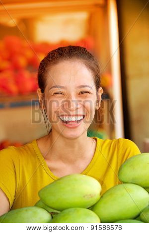 Pretty laughing girl fruit market seller
