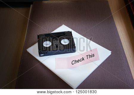 Mini Dv Cassette Tape On Note Text Word Check In Dim Light Room Nackground With Copy Space
