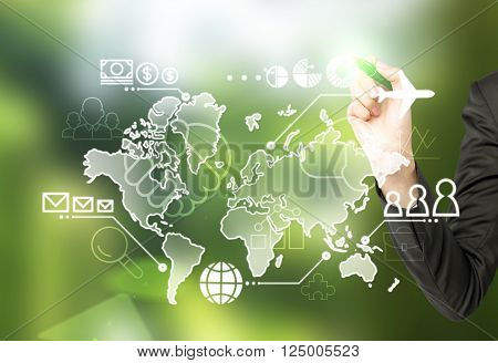 Hand touching virtual map drawn on blackboard money people and communication points and plane on it. Concept of business logistics.