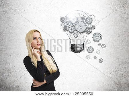 Idea concept with pretty businesswoman and lightbulb and gear sketch on concrete wall