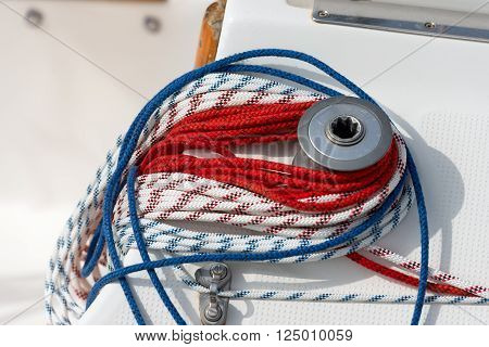 Detail of a sailboat deck with a winch and nylon ropes