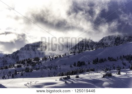 Sunny clouds in the snowy mountains in the rockies