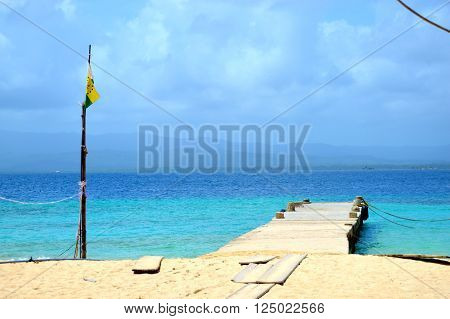 Alone yellow flag and pier in a beach of a desert island in Panamá