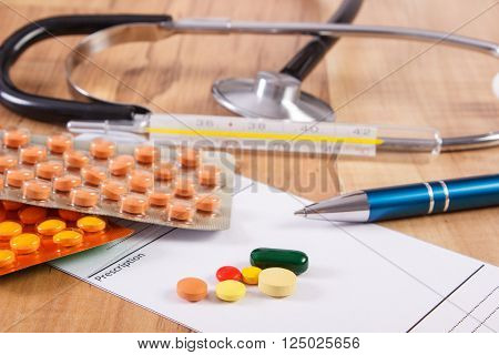 Medical pills tablets or supplements for therapy prescription thermometer and stethoscope on desk in doctor office concept of treatment and health care