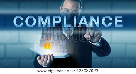 Business manager is touching COMPLIANCE on a virtual interactive screen. Business challenge metaphor and information technology concept for conforming to corporate rules and regulations.