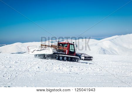 snowcat on a snowy mountain and green tree