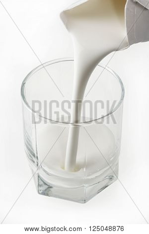Pouring a fresh glass of kefir - milk product on white background