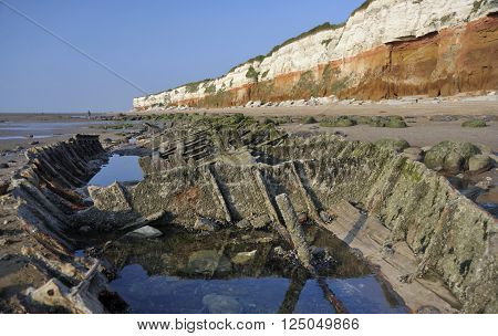 The cliffs beach and shipwreck remains on the beach at Hunstanton in Norfolk UK.