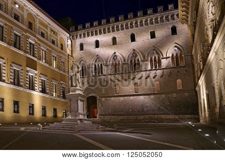 SIENA ITALY - MARCH 11 2016: Sallustio Bandini on Piazza Salimbeni at night Siena Tuscany - Italy.