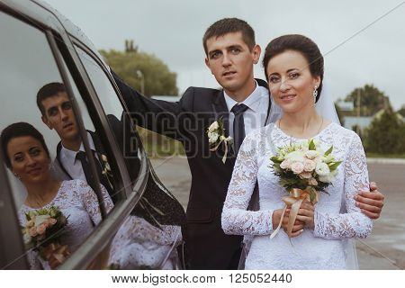 Bride with groom reflexion in a windowpane of car