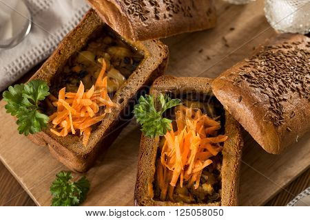 Fresh pea soup in a Bread Bowl, on a wooden board with salt and papper