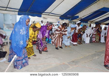 Abidjan, Ivory Coast- February 26, 2015: Women dance during a traditional wedding ceremony. Aligned all women perform the same movements which give harmony.