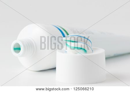 toothpaste tube with a small amount of toothpaste on the cap