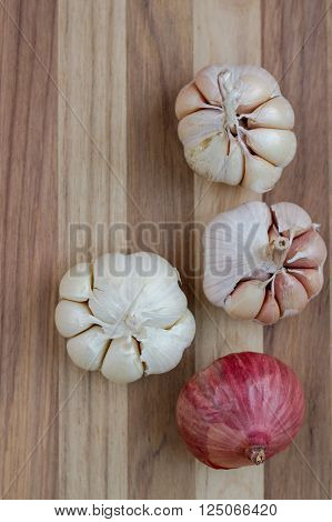 Artistic onion and garlic on wooden table.