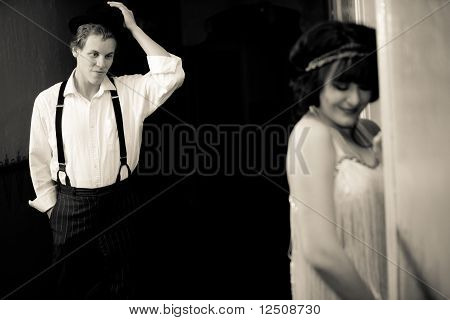 Atrakcyjny młody 1920 facet flirtuje z młoda, ładna Flapper Girl poza pokoju.