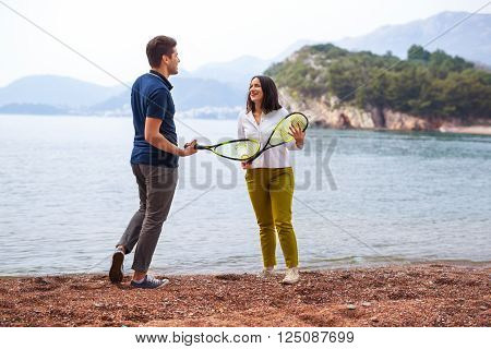 Two young people playing on the seashore speedminton - badminton