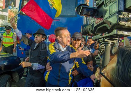 Quito, Ecuador - April 7, 2016: Closeup opposition leader Andres Paez surrounded by people, police and journalists during anti government protests in Shyris Avenue.