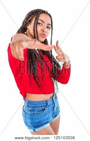 Funny picture of audacious african young woman. Girl with African braids looking at camera and making shooting gesture. Isolated background