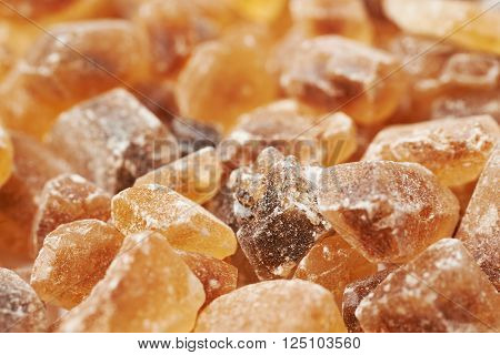 Surface coated with multiple large brown rock sugar crystals as a background composition