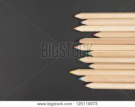 Colour pencils on black background. free space for text.