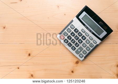 Calculator on wooden table background. free space for text.