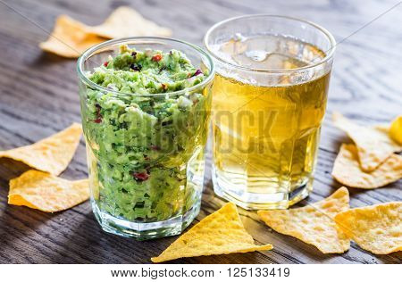 Guacamole with tortilla chips and glass of beer