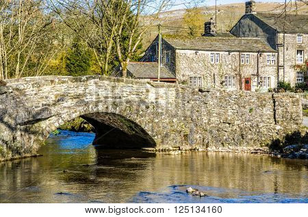 Stone bridge over a river in Malham village, Craven, Yorkshire, England.
