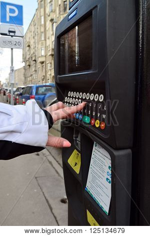 Moscow, Russia - March 14, 2016. Woman's hand enters the data in the parking payment machine