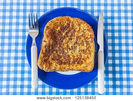 a stack of golden french toast on a blue plate