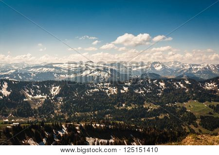 View from Hochgrat in the Alps with snowy peaks on a spring morning in May and blue sky