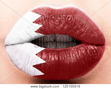 Female lips close up with a picture of the flag of Katar. Red and white.