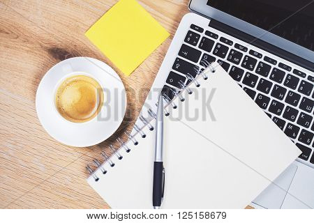 Topview of desktop with laptop coffee notepad and yellow stickers