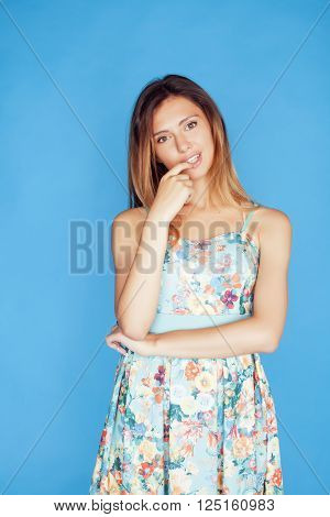 young pretty adorable woman close up like doll posing, natural makeup emotional gesturing on blue background