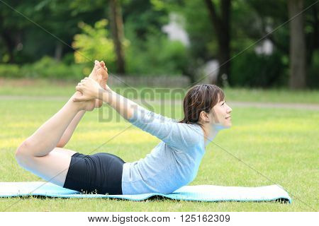 Japanese woman outside doing yoga frog pose