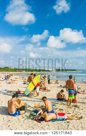 Kuta,Indonesia - JULY 24 : Tourists relax on Kuta Beach on the 24th of july 2009 in BaliIndonesia. Bali is a popular holiday destination especially for young australian and backpackers