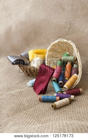 Handicraft supplies in basket on burlap background