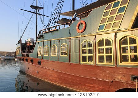 replica of the medieval pirate warship is used for tourist trips along the coast of Crete, Greece. Sunset light