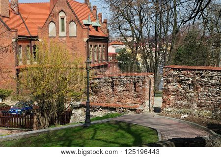 Wieliczka, Poland - April 04, 2016: Saltworks Castle. Fragment of the defensive walls of the fifteenth century. On the left Wieliczka district Office.