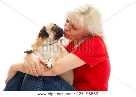 A woamn in a red shirt kissing a pug