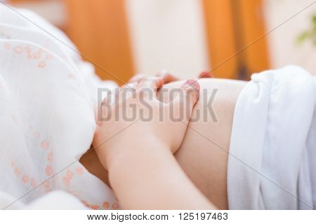 Little child holding the tummy in pain in the bed.