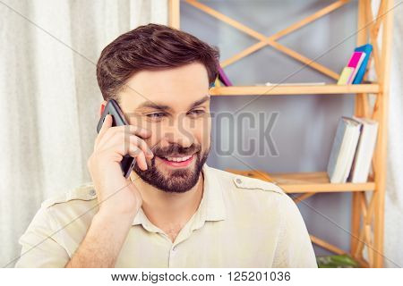 Happy businessman talking on mobile phone, close up portrait