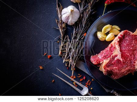 Raw Meat Steak Entrecote On The Plate With Spice On The Dark Table.
