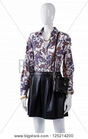 Mannequin wearing bag and shirt. Lady's black retro purse. Leather skirt with vintage handbag. Luxury apparel and gold bracelet.