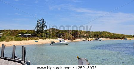 ROCKINGHAM,WA,AUSTRALIA-NOVEMBER 8,2013: Boating recreation in the turquoise Indian Ocean waters with a beach, dunes and tourists at Penguin Island in Rockingham, Western Australia.