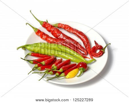lot of different hot chilli peppers on white plate