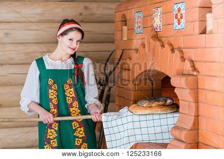 Woman Bakes Bread In A Russian Stove
